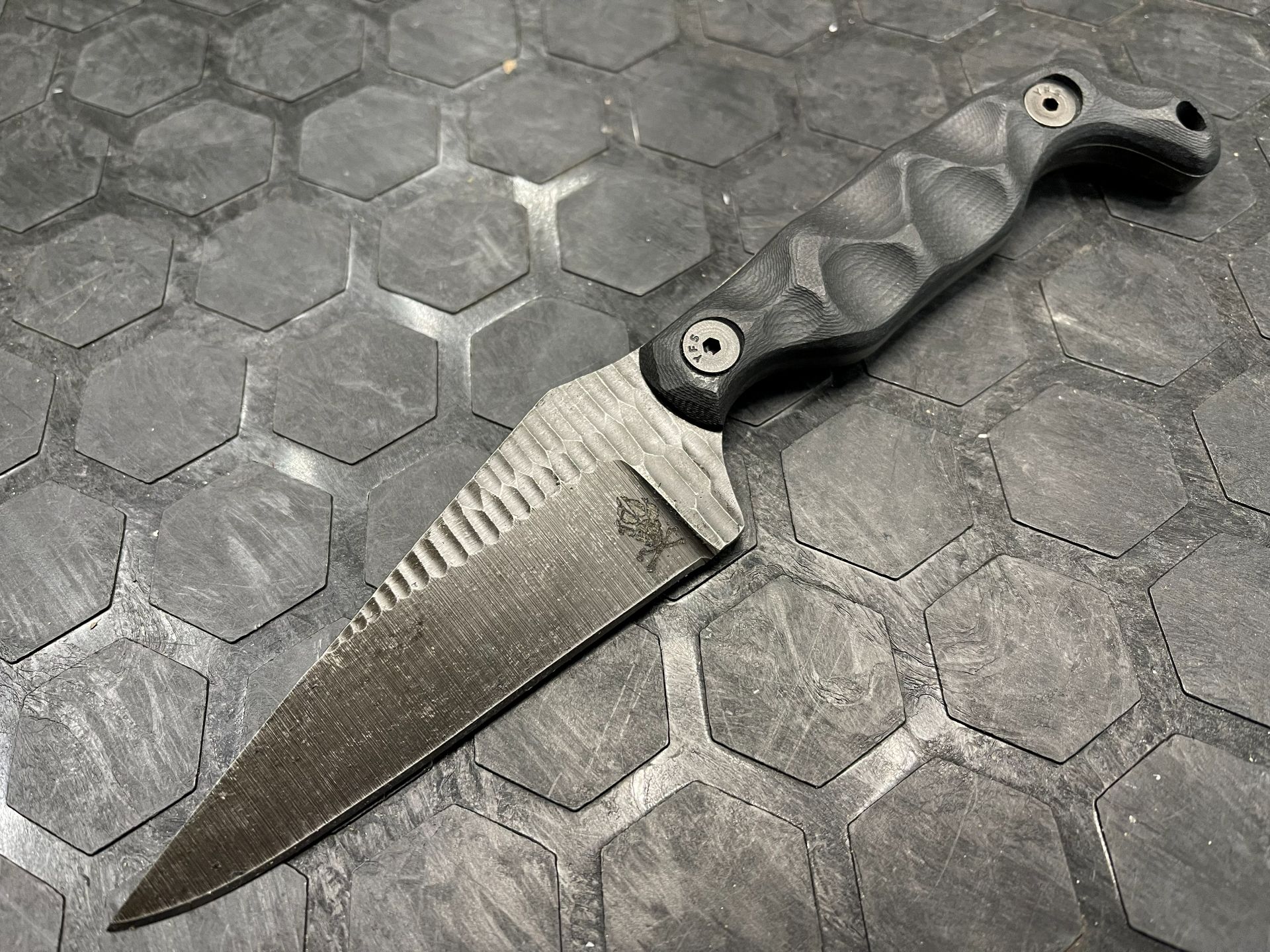 Close-up of the laser-etched paw and crossed bones on the Bravo 5 blade.